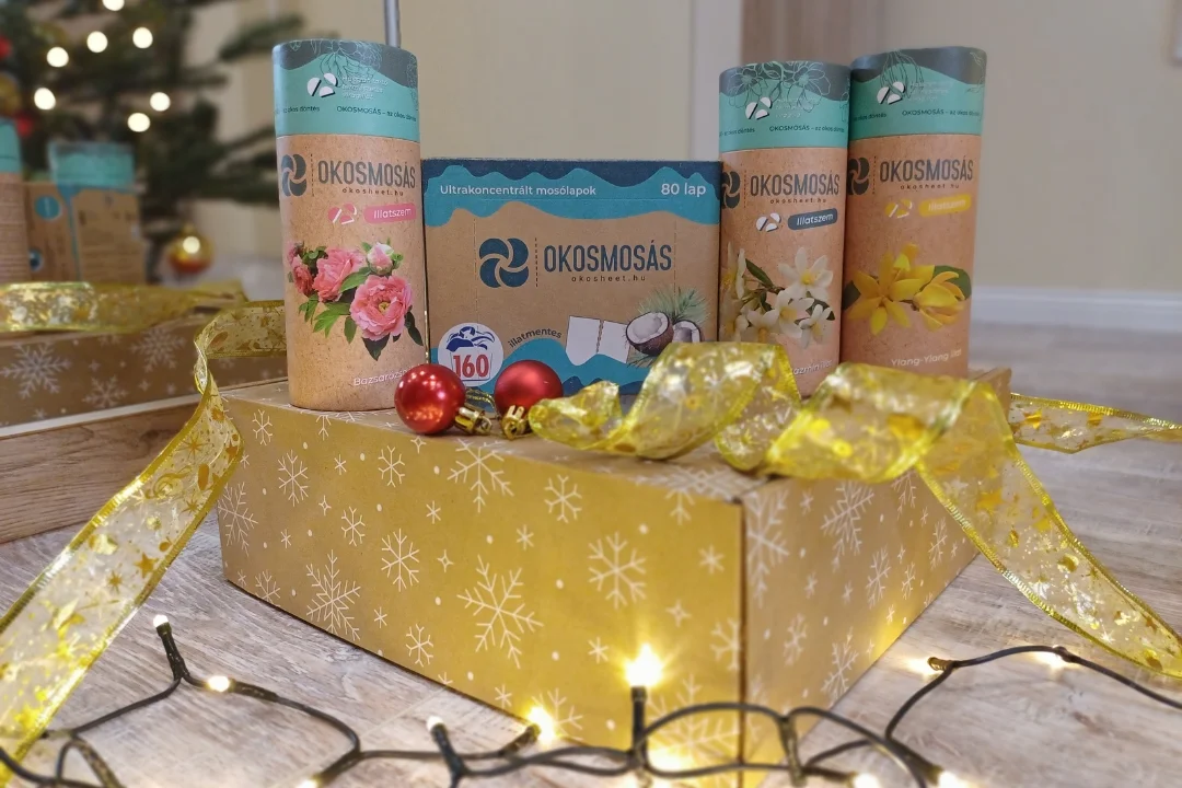 karácsonyi díszcsomagolás a karácsonyfa alatt rajta okosmosás mosólap és illatszemek termékek